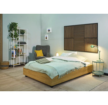 Svetlá spálňa s drevenou posteľou, akustickým panelom na stene, kreslom a regálom