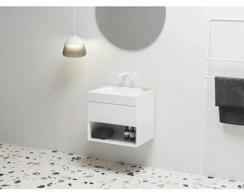 Moderná kúpeľňa s umývadlovou skrinkou, okrúhlym zrkadlom a držiakom na uteráky