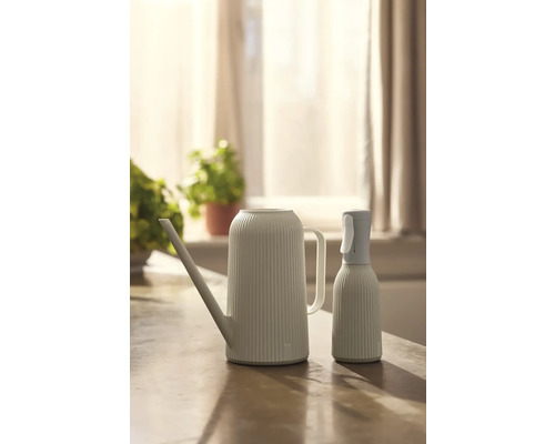 Kanva na polievanie a rozprašovač na rastliny na stole.