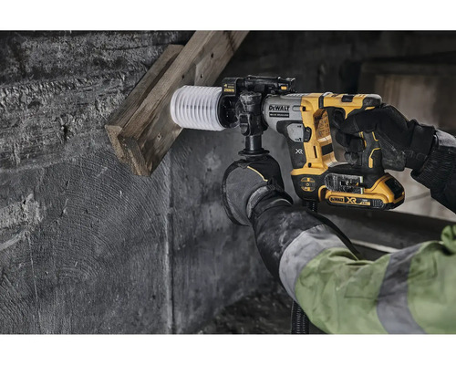 Osoba vŕta do steny s vŕtacím kladivom DeWalt a odsávaním prachu.