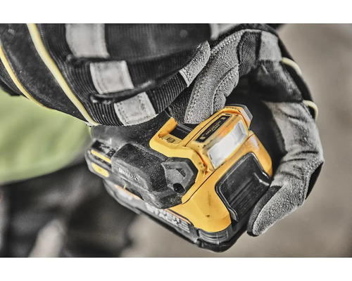 Osoba v rukaviciach drží akumulátorové pracovné svetlo DeWalt.