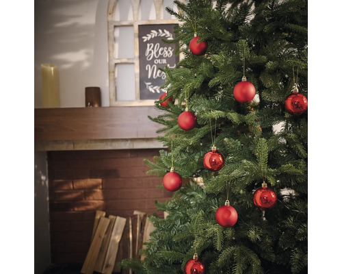 Ozdobený vianočný stromček s červenými guľami v obývacej izbe.