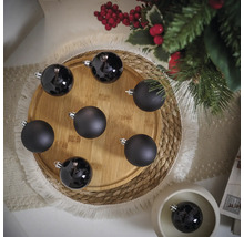 Dekoratívne čierne vianočné gule na drevenom tanieri