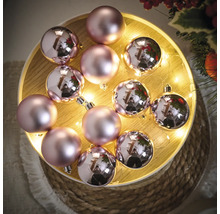 Dekoratívne ružové vianočné gule na osvetlenom podnose.