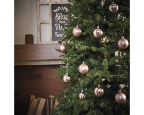 Ozdobený vianočný stromček s ozdobami pred krbom