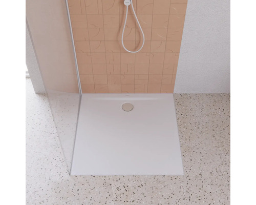 Štvorcová sprchová vanička z umelého kameňa s odtokovou armatúrou v sprche.