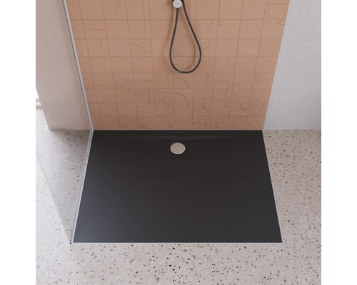 Sprchovací kút v úrovni podlahy s plochou, tmavou sprchovacou vaničkou a sprchovou hlavicou