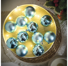 Dekoratívne modré vianočné gule so svetelnou reťazou na tanieri