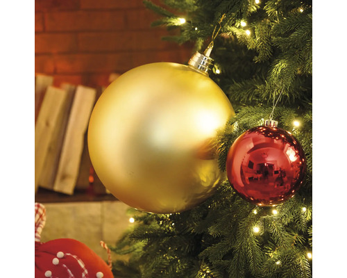 Detail vianočného stromčeka so zlatými a červenými ozdobami a svetlami