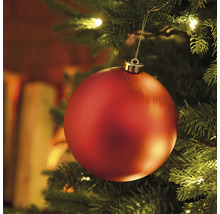 Detailný záber červenej vianočnej gule na vianočnom stromčeku so svetlami