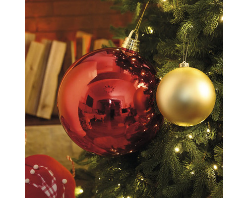 Detailný záber červených a zlatých vianočných gúľ na vianočnom stromčeku so svetielkami