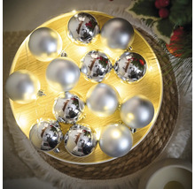 Strieborné vianočné ozdoby na osvetlenej drevenej tácke