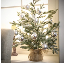 Dekoratívny, malý, umelý vianočný stromček so striebornými guľami v jutovom vreci