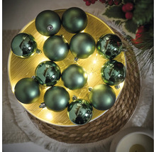 Dekoratívne zelené vianočné gule na osvetlenom tanieri