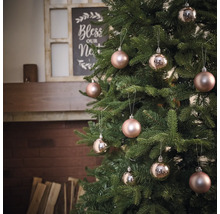 Ozdobený vianočný stromček s guľami pred krbom