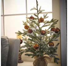 Zdobený zasnežený vianočný stromček s hnedými ozdobami v jutovom vreci