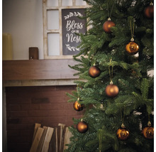 Ozdobený vianočný stromček s guľami pred krbom