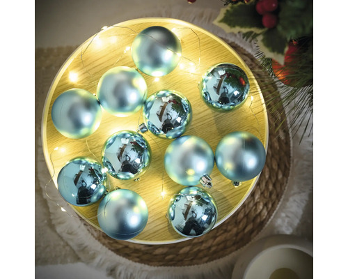 Ozdobné modré vianočné gule na podnose so svetelnou reťazou