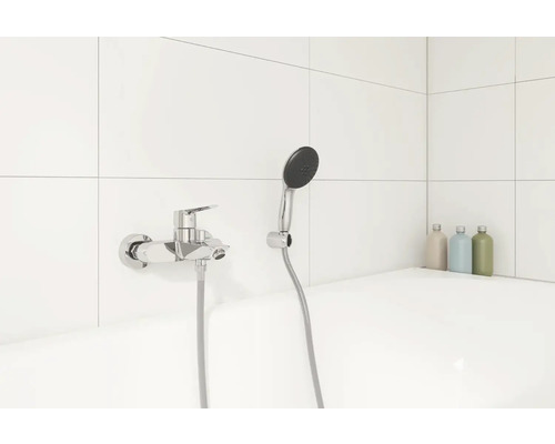 Fotografia vane s batériou a sprchovou hlavicou v kúpeľni.