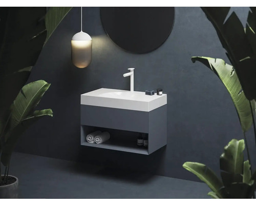 Umývadlo s umývadlom, batériou, zrkadlom, lampou a uterákmi v kúpeľni