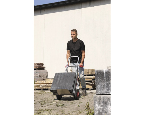 Muž prepravuje dlažobné kocky s rudlom.