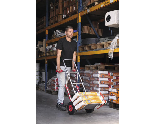 Muž prepravuje vrece s tovarom pomocou rudla v sklade.