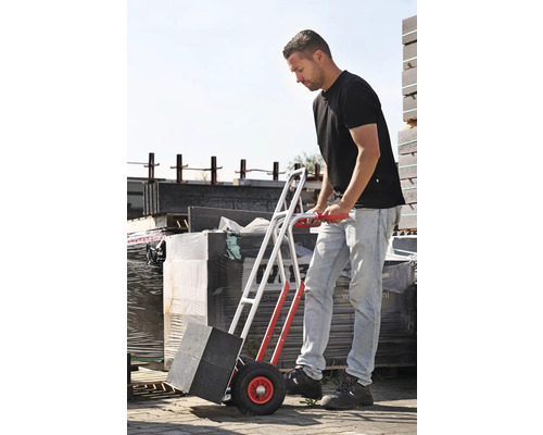 Muž prevozí dlažobné kocky s rudlom.