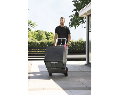 Muž prenáša krabicu s rudlom vonku.