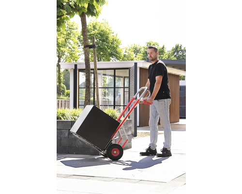 Muž prepravuje čierny balík na rudli vonku.