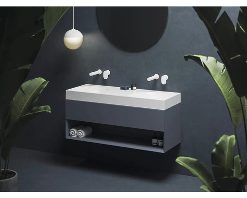 Moderná kúpeľňa s dvojitým umývadlom, okrúhlym zrkadlom a závesným svietidlom.