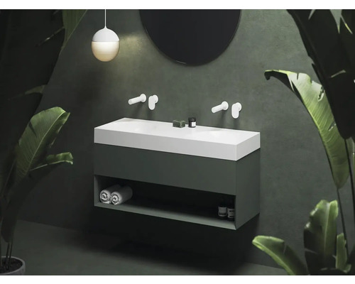 Moderná kúpeľňa s umývadlovou skrinkou, umývadlom na dosku a okrúhlym zrkadlom.