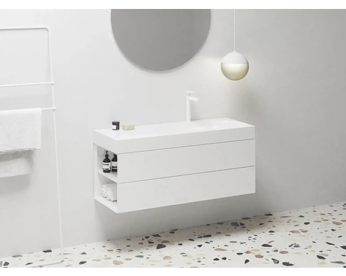 Moderná kúpeľňa s bielou skrinkou pod umývadlo, okrúhlym zrkadlom a držiakom na uteráky