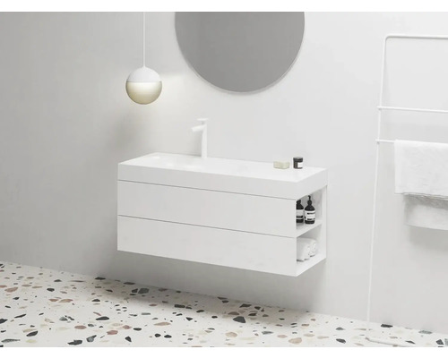 Moderná kúpeľňa s bielou skrinkou pod umývadlo, okrúhlym zrkadlom a držiakom na uteráky