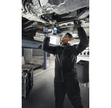 Mechanik používa akumulátorový rázový uťahovák na prácu na aute, ktoré je na zdviháku.