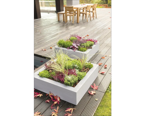 Dva osadené obdĺžnikové betónové kvetináče na terase s drevenou podlahou