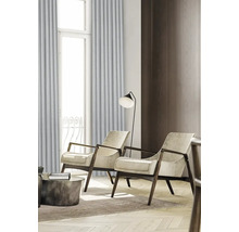 Obývacia izba s dvomi kreslami, stojacou lampou a závesmi pred oknom