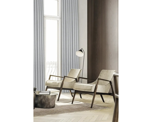 Obývacia izba s dvomi kreslami, stojacou lampou a závesmi pred oknom