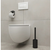 Závesné WC s držiakom na toaletný papier a toaletnou kefou v kúpeľni.