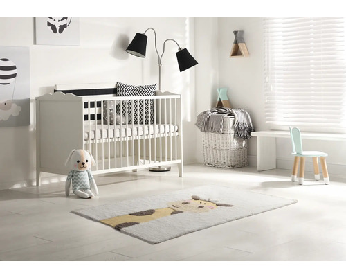 Svetlá detská izba s postieľkou, stojacou lampou, detskou stoličkou a kobercom so zvieracím motívom