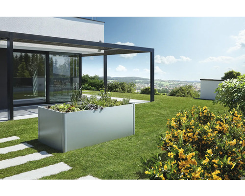 Kovový vyvýšený záhon v záhrade s rastlinami a priľahlou terasou