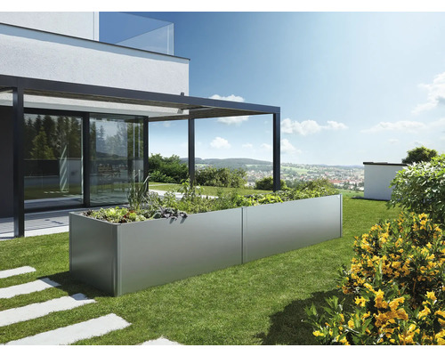 Podlhovastý kovový kvetináč v záhrade