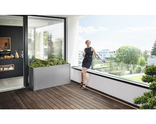 Balkónová scéna s kvetináčom, ženou a pohľadom do kuchyne