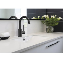 Kúpeľňové umývadlo s batériou, uterákom a vázou s kvetmi