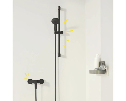 Čierna sprchová súprava s tyčou a odkladacou plochou v kúpeľni.