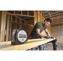 Zvinovací meter Stanley Fatmax vedľa remeselníka pracujúceho s drevom