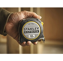 Zvinovací meter Stanley Fatmax s dĺžkou 10 metrov držaný v ruke.
