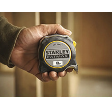 Ruka drží zvinovací meter Stanley Fatmax s dĺžkou osem metrov