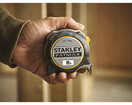 Ruka drží zvinovací meter Stanley Fatmax s dĺžkou osem metrov