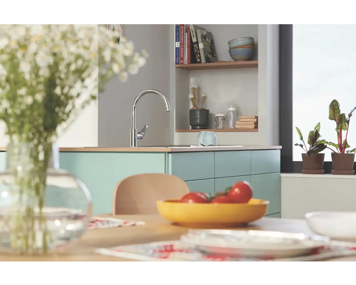 Kuchynská scéna s drezovou batériou, jedálenským stolom a dekoráciami