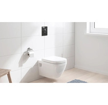 Závesné WC s ovládacou doskou a držiakom toaletného papiera v kúpeľni s bielymi obkladmi.